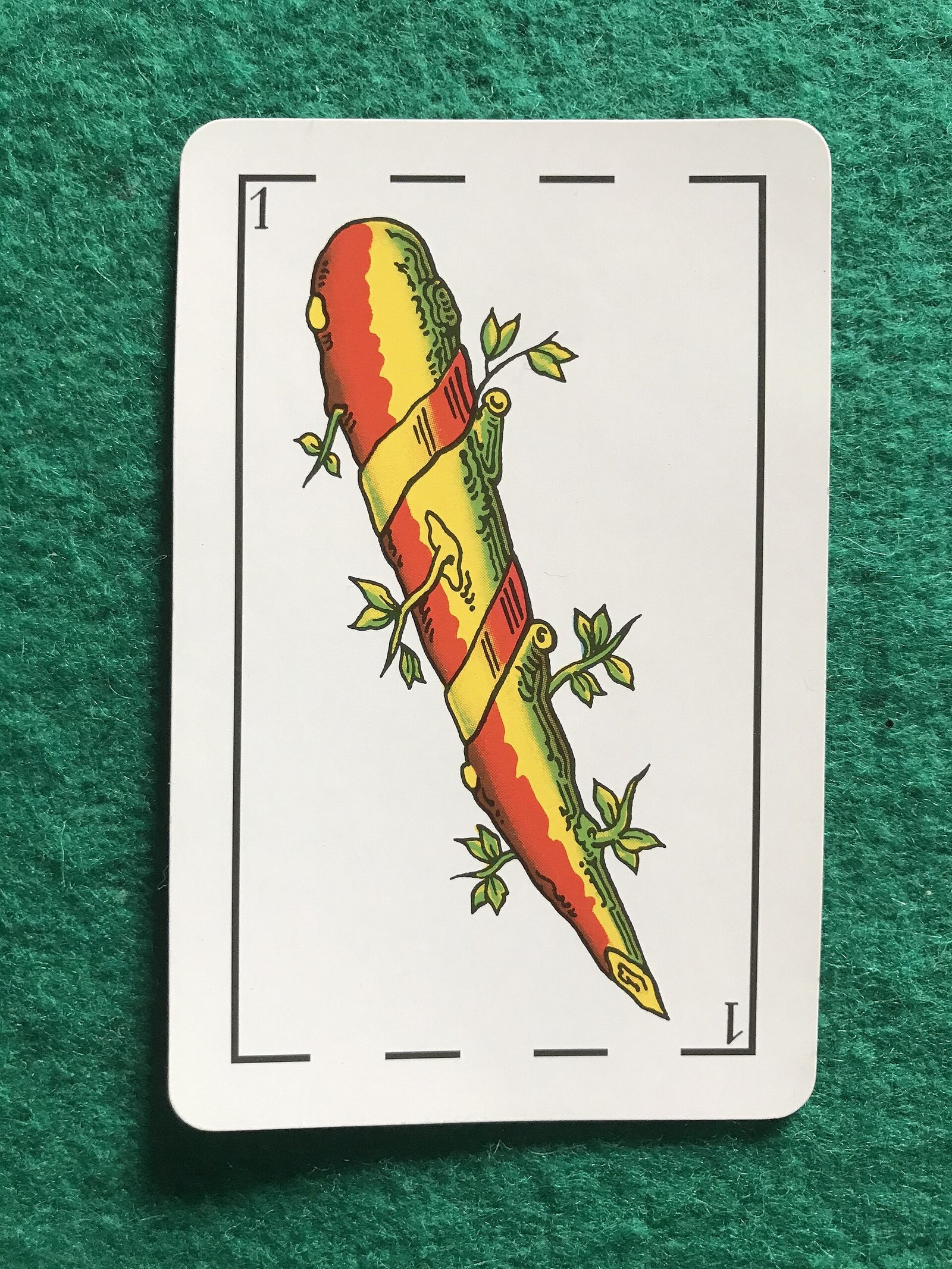 The Ace of Wands from a Heraclio Fournier Spanish card deck, a single sprouting wooden club painted red, yellow, and green on a white card.