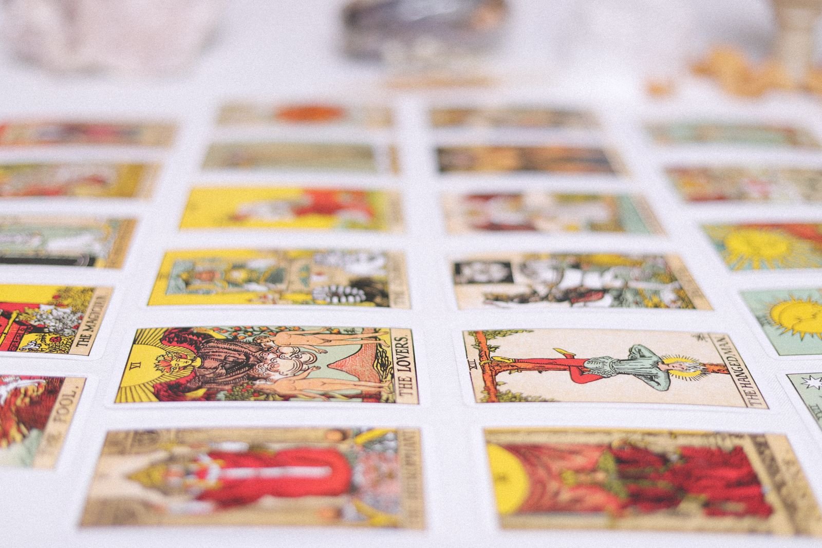 A grid of face-up Rider-Waite tarot cards including The Lovers, The Hanged Man, The Fool, and The Magician.