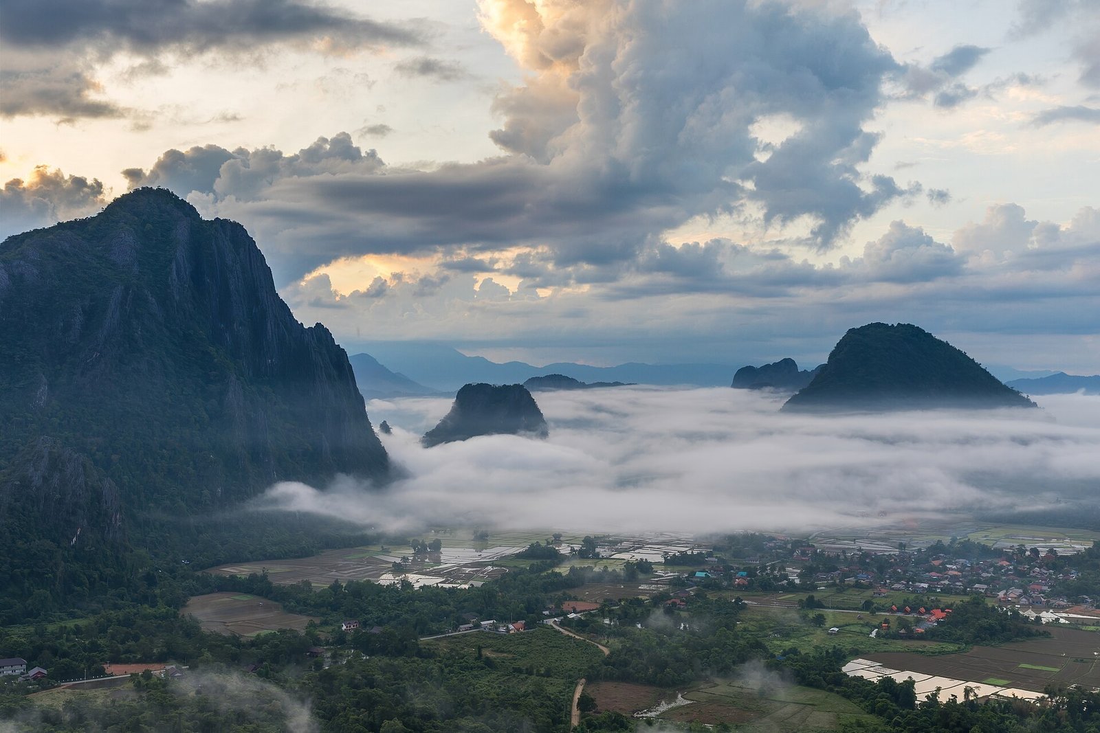 A mountain peak rising above a sea of clouds at dawn, solid rock and snow catching the first light.