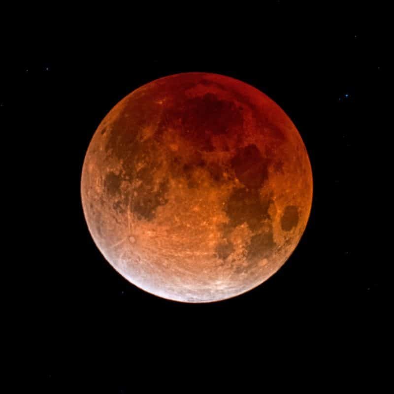 Reddish blood moon during a total lunar eclipse in a dark sky