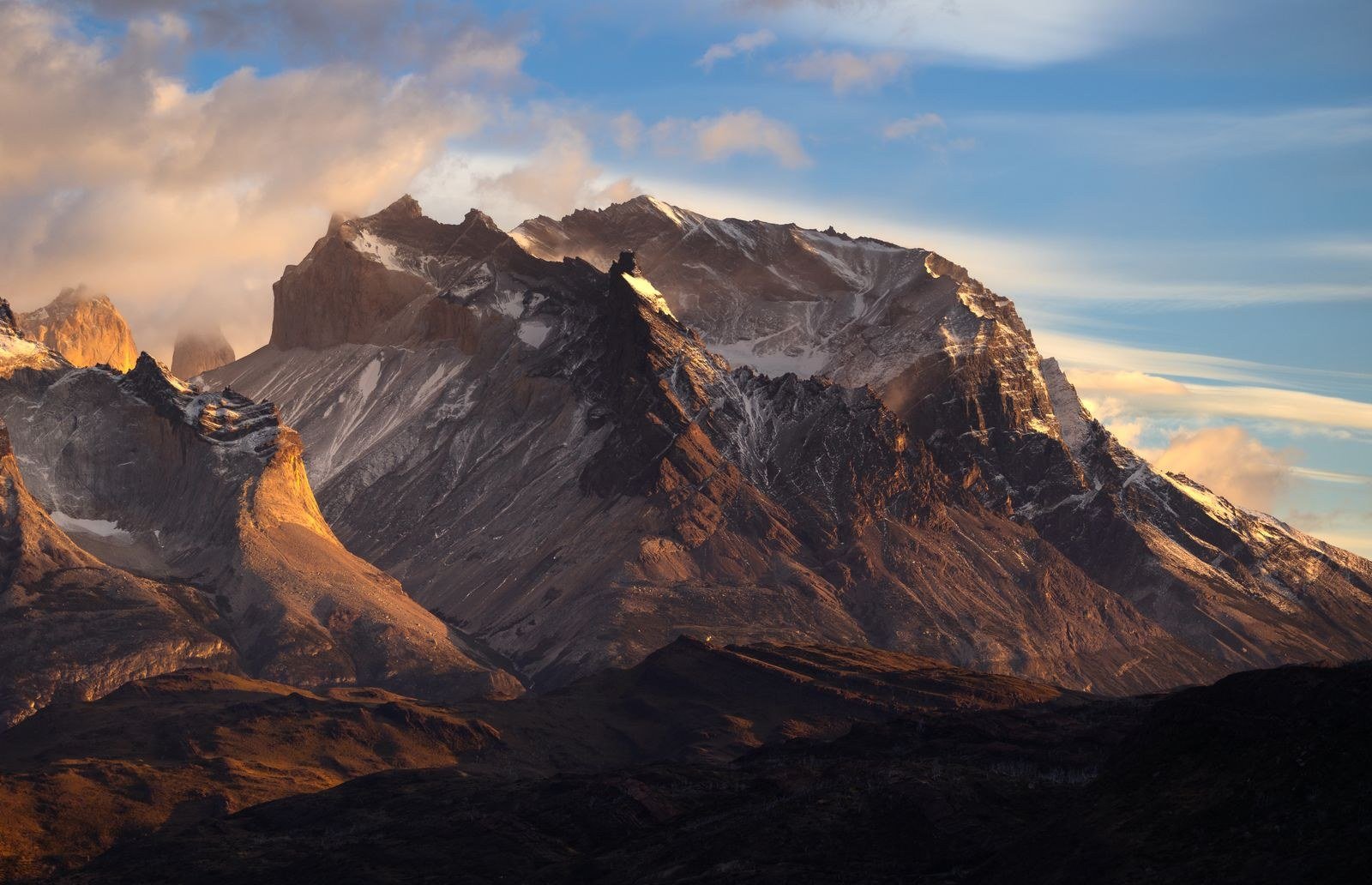 Golden sunrise light on rugged mountain peaks.