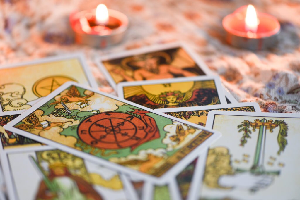 A tarot card lit by candlelight against a dark background