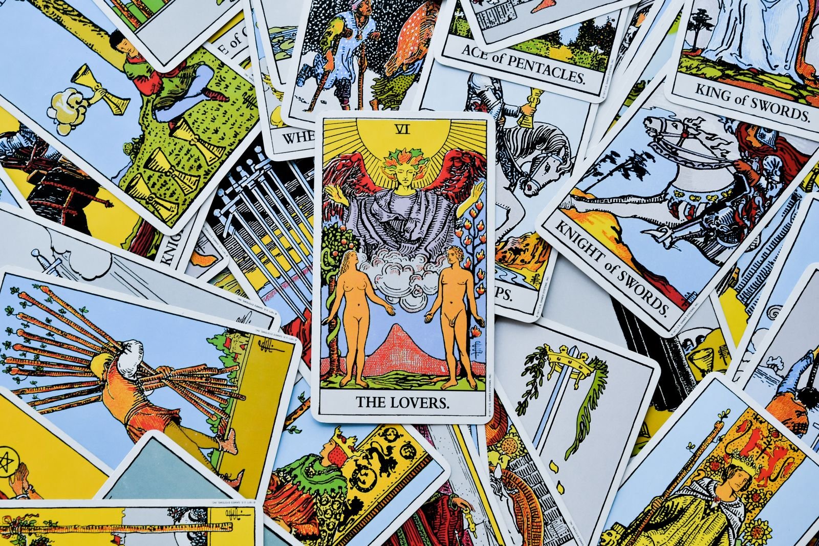 Rider-Waite tarot cards scattered face up, the Lovers card prominent
