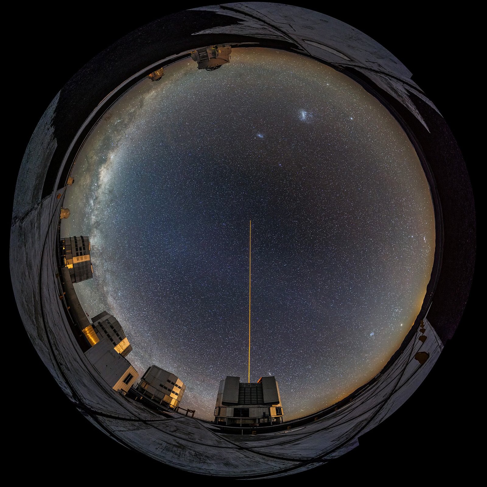 An astrophotographer at work under a starry sky at an ESO observatory
