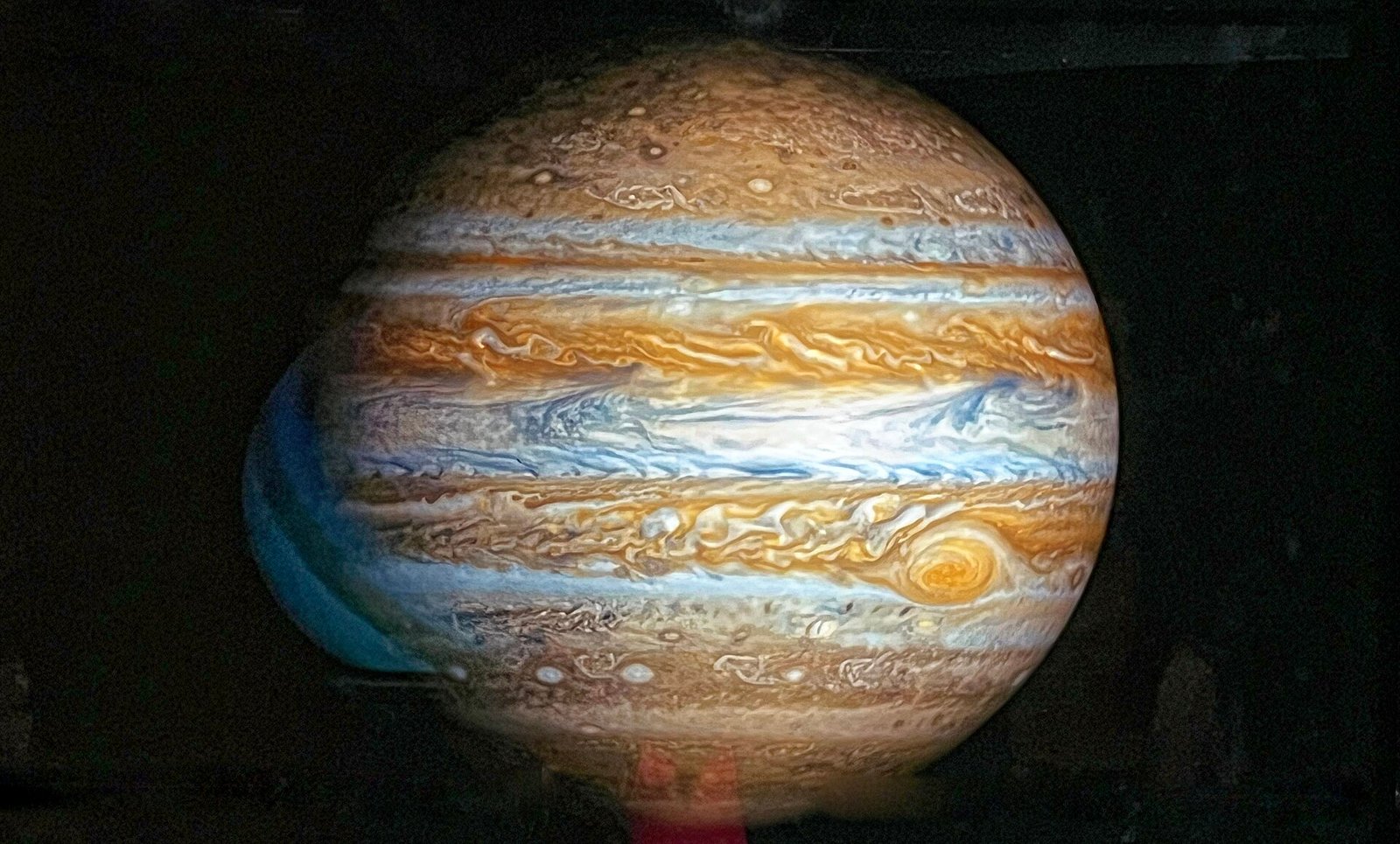 A large museum model of Jupiter showing its banded clouds and the Great Red Spot.