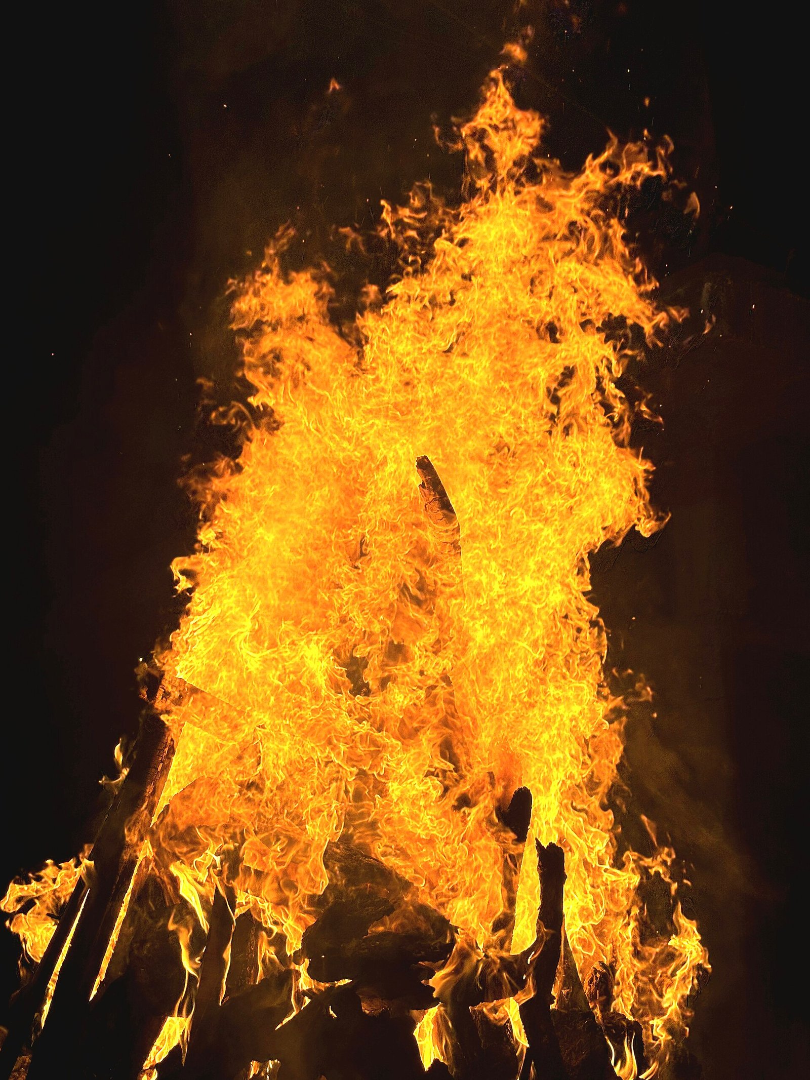 A bonfire burning bright against a dark night sky