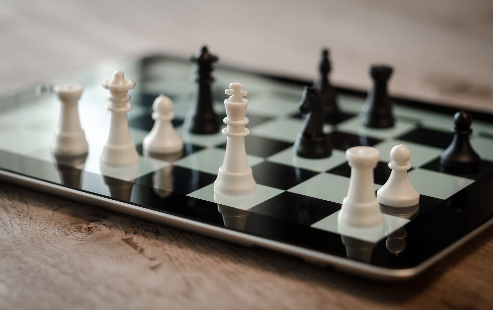 A close-up of chess pieces on a wooden board, a dark knight beside white pawns in mid-game.