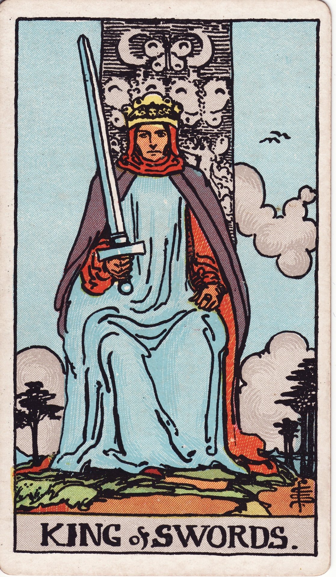 The King of Swords from the Rider-Waite-Smith deck, a crowned king seated on a throne holding an upright sword against a pale blue sky.