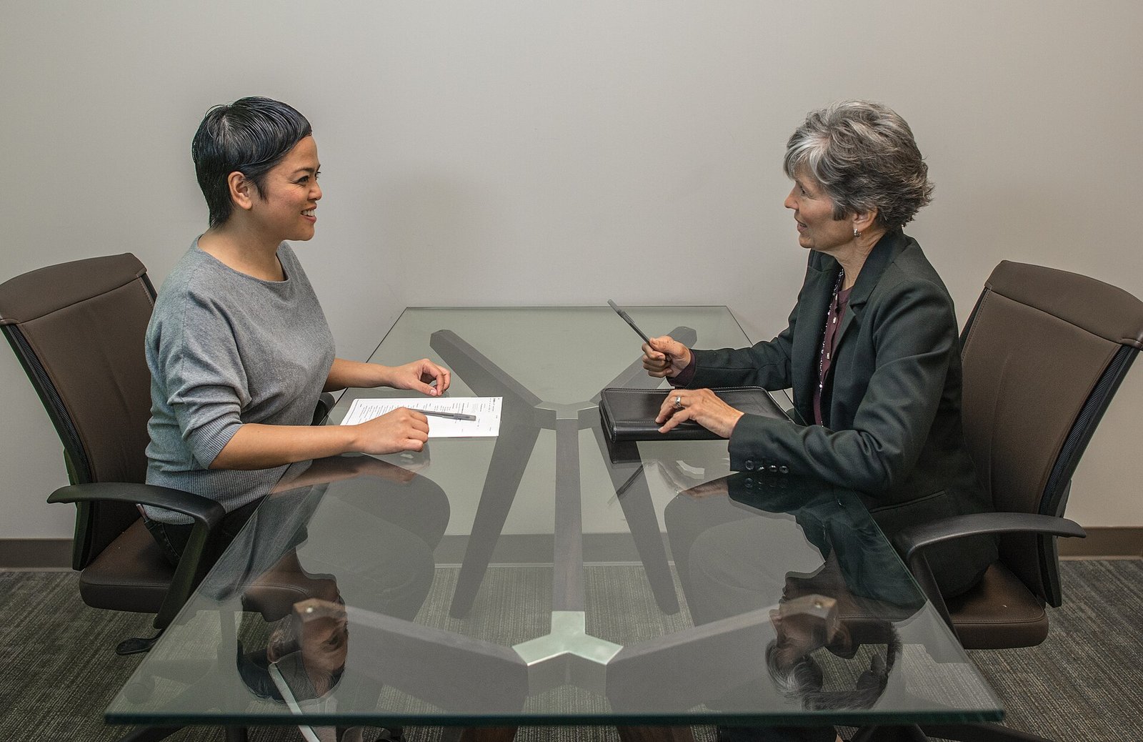 Two women in a job interview across a glass conference table