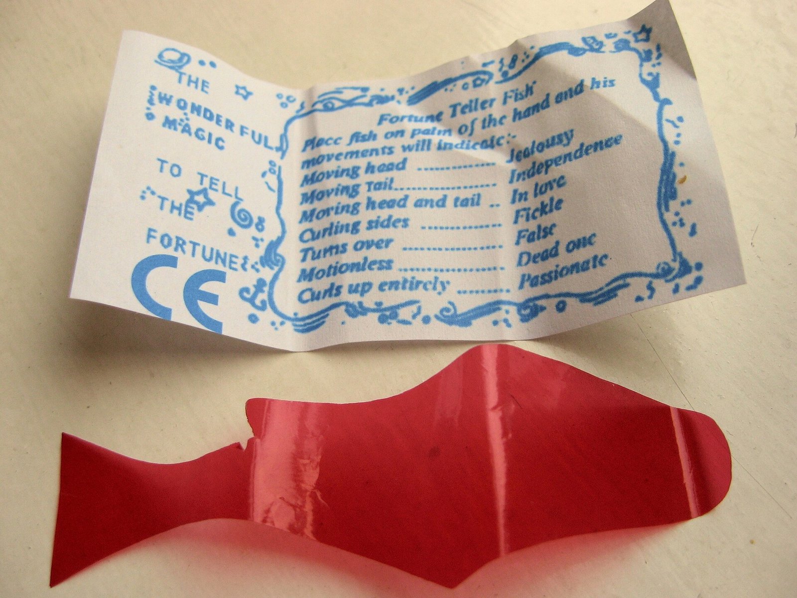 A paper fortune-teller fish novelty with printed predictions on its wrapper