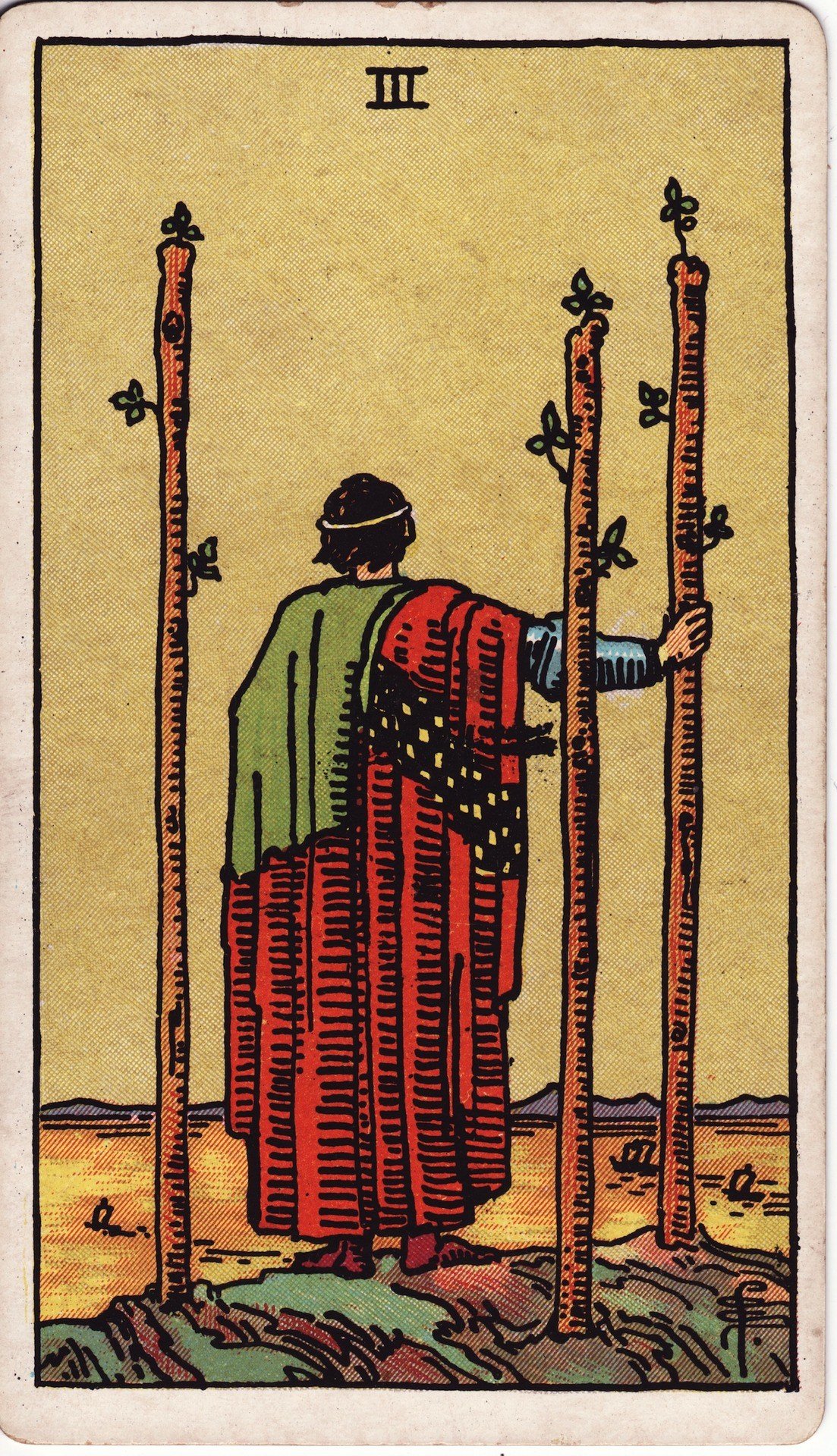 The Three of Wands from the Rider-Waite-Smith tarot deck: a figure with back turned stands on a cliff holding a wand, watching three-masted ships sail across a wide bay, two more wands planted beside him.