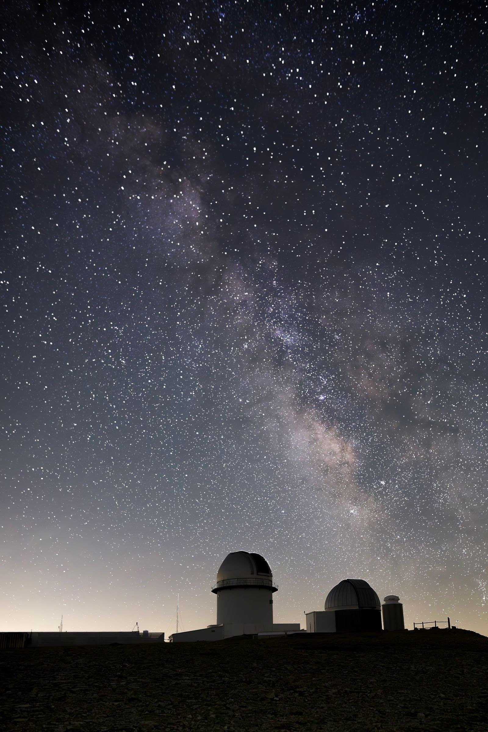 A large telescope dome open to a starry night sky.