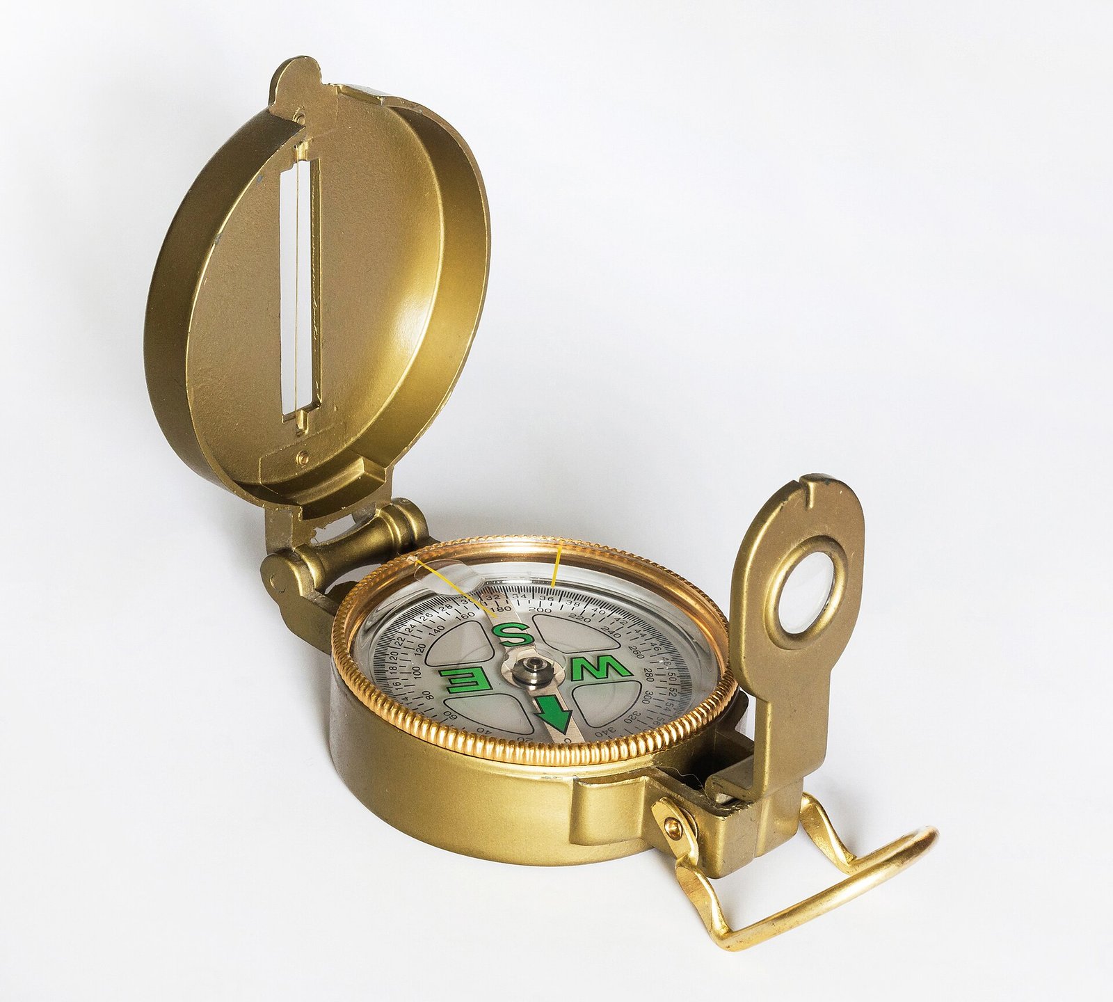 A brass compass on a white background