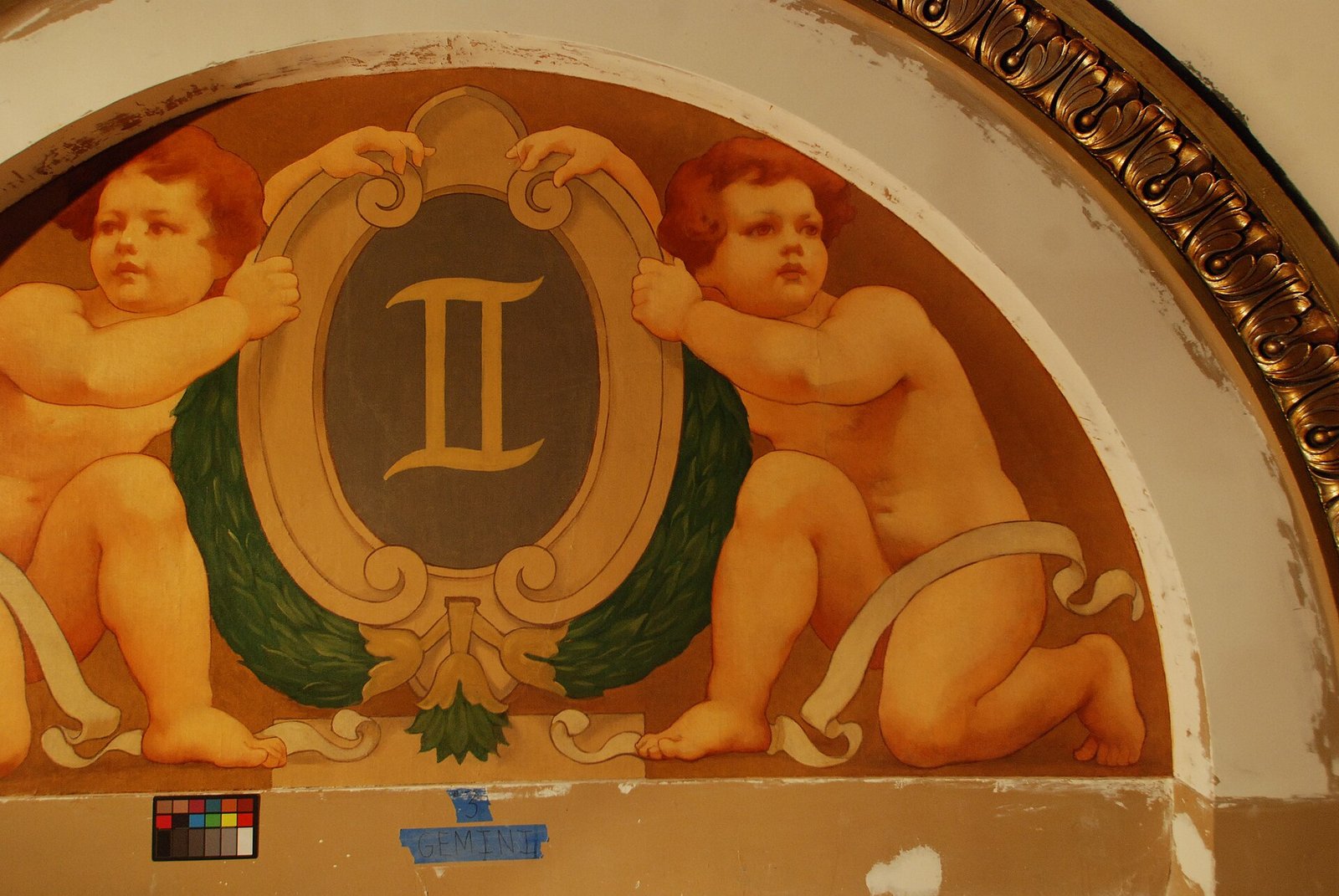 Restored mural of two cherubs flanking a Gemini zodiac medallion